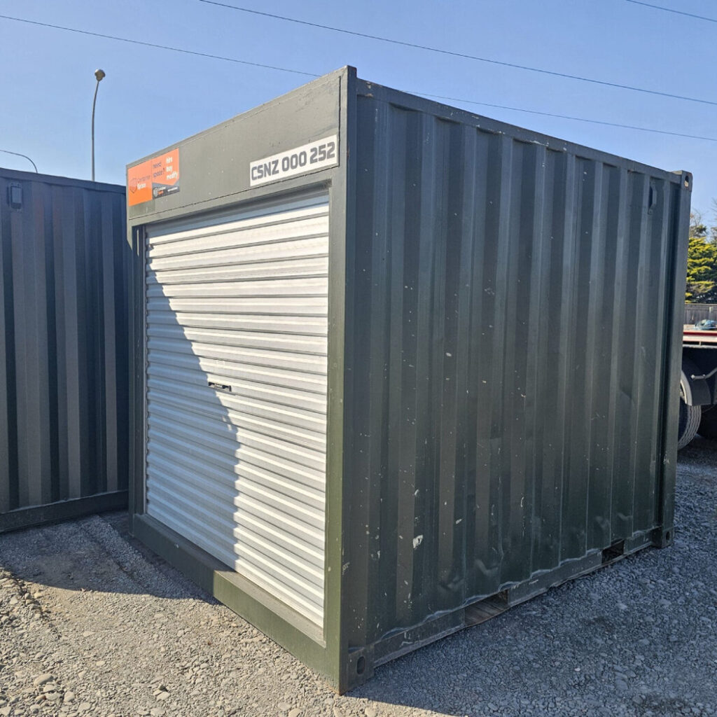 Olive green container with a roller door on a gravel site